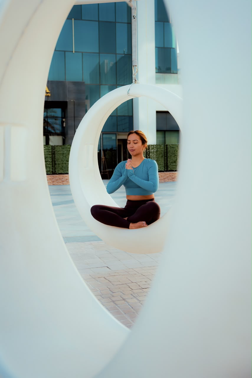Alyson Fajardo mindful meditation in circular swing sculpture